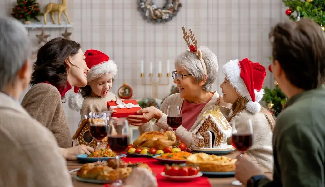 Family gathered around the dinner table during the holidays, sharing gifts and enjoying a clean, festive home